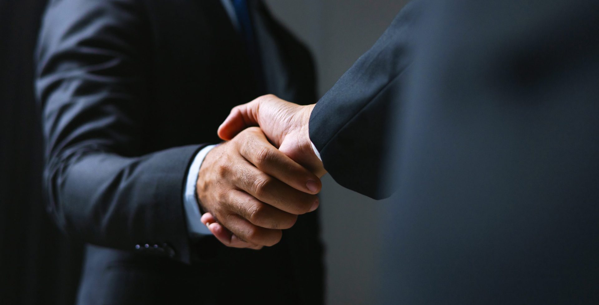 Two men shaking hands in  business setting. Scene is professional and formal